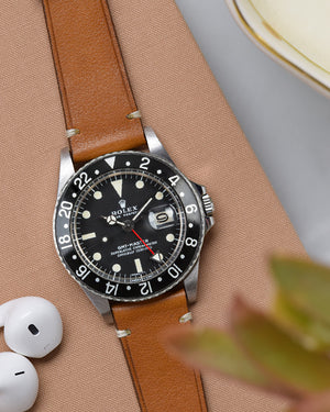 guilt rolex submariner on brown watch strap