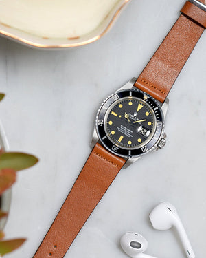 rolex submariner with light brown watch strap